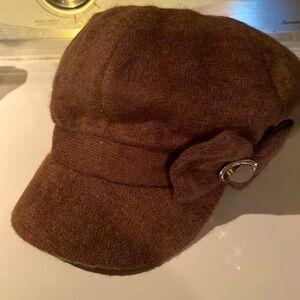 Brown ladies hat with brim, and bow/bling decoration on side.